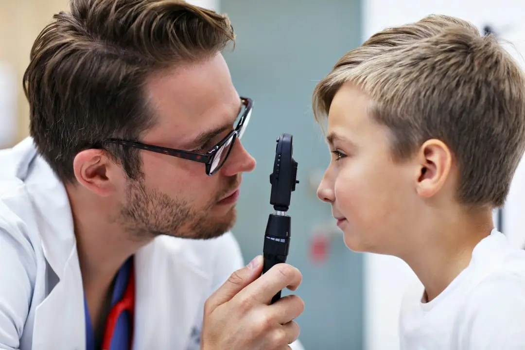 Optometrista examinant la vista d'un nen